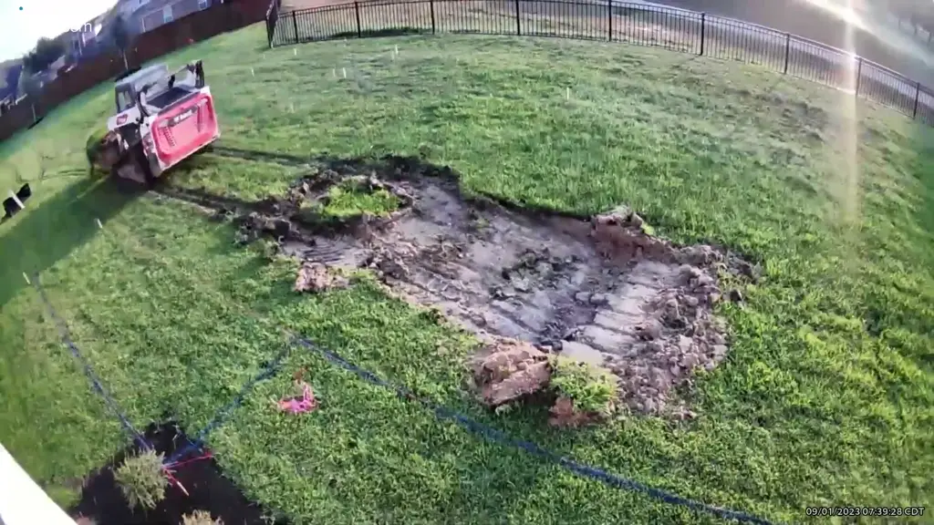 Excavation begins — stakes and machinery mark the pool's shape in the backyard lawn.
